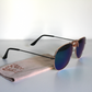 Sunglasses with blue-green lenses and matte-black arms. Beer Eyed sunglasses cloth under sunglasses. Left-view