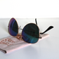 Sunglasses with blue-green lenses and matte-black arms. Beer Eyed sunglasses cloth under sunglasses.